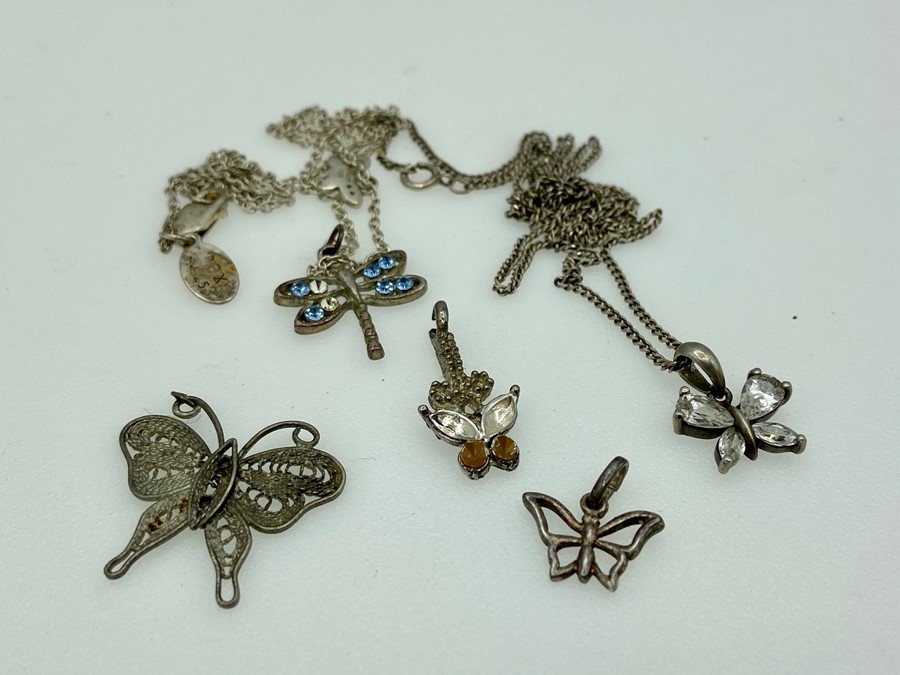 Two butterfly necklaces with other pendants