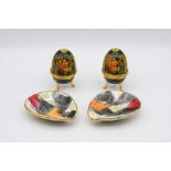 Two German pin trays with two West German Balttrade International porcelain eggs depicting religious