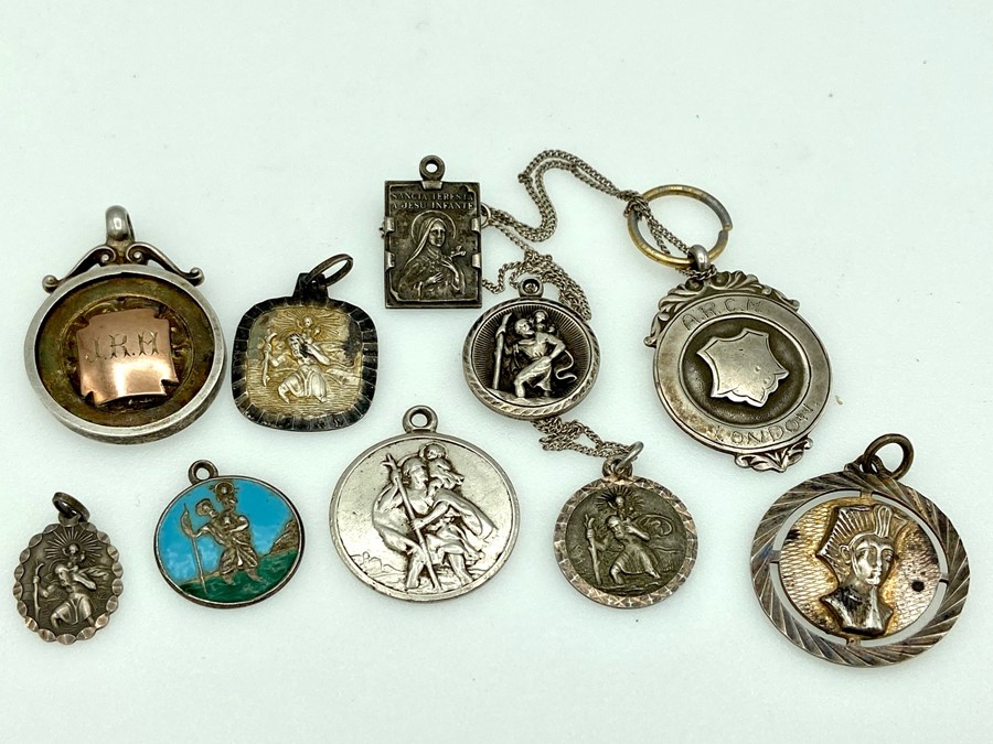 A collection of St Christopher pendants and other pendant medals