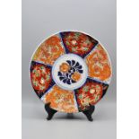 An antique Japanese Imari plate with "gold" decorated central flower and panels with honey pot and