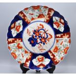 An antique Japanese Imari plate with sculpted edge 30cm wide (minor repair)