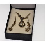 An elegant pendant silver necklace with a pair of droplet earrings