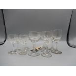 5 cut glass stemmed glasses and 7 etched and cut glass stemmed wine glasses, and 2 straight sided