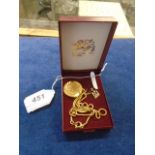 A false Sovereign on chain and a pair of hair combs and a 9 ct gold pendant in box