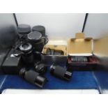 A box of Various cased camera lenses including Olympus etc..