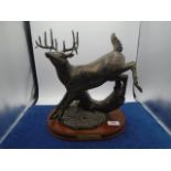 Montana Lifestyles cast stag leaping over tree titled "Over and Gone" on wood base, approx 30cm long