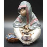 Lladro seated boy with basket of fish figurine
