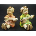 Two ceramic Goebel style figures playing a guitar