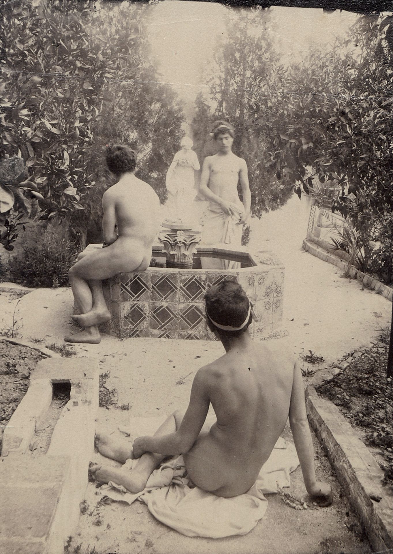 Gloeden, Wilhelm von: Male nudes in gardenMale nudes in garden. 1890s. Albumen print. 17 x 12 cm.