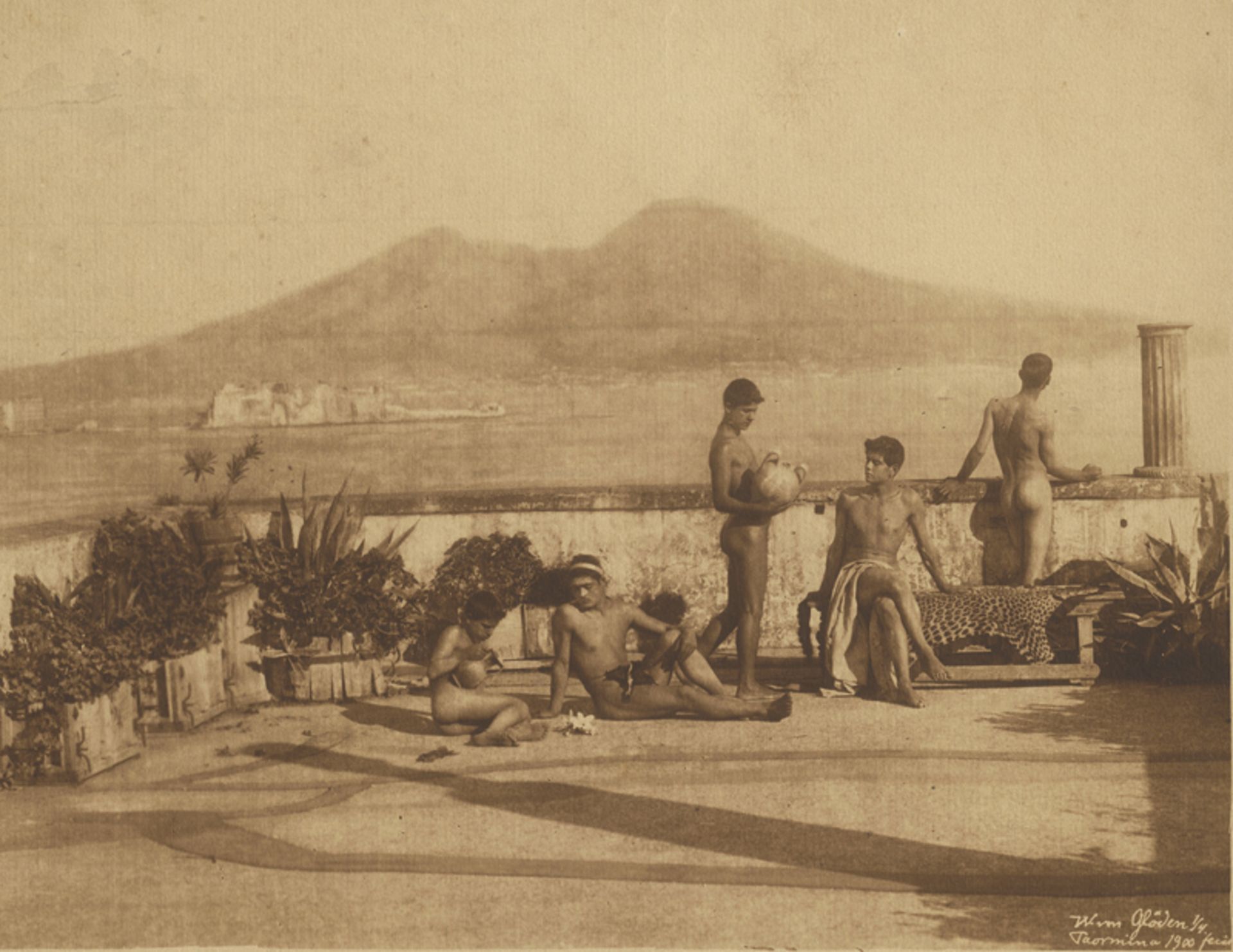 Gloeden, Wilhelm von: Nude youths on terrace with Naples harbor view in background