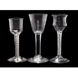 Three English wine glasses: one with hammered rounded funnel shaped bowl on a straight stem and