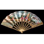 A 19th century French ivory painted fan: the paper leaf decorated with figures seated in a wooded