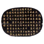 A Chinese black lacquer panel: of rounded rectangular form, incised and gilded with calligraphy,