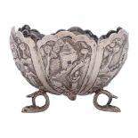 A South East Asian silver dish: of lobed circular form, with embossed decoration of village scenes,