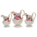 A graduated set of three early 19th century English porcelain jugs: of nautilus shell moulded form