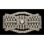 A French Art Deco diamond mounted rectangular plaque brooch: of pierced stylised ribbon bow design