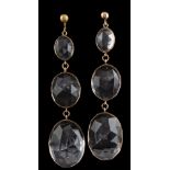 A pair of faceted quartz crystal three-stone drop earrings: each with three graduated oval drops