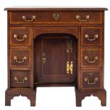 A George III mahogany later satinwood crossbanded and inlaid kneehole desk:,
