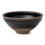 A small Chinese black-glazed bowl: of rounded form with everted rim,