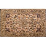 A Tabriz rug:, the beige cartouche field with a central light brown geometric pole medallion,