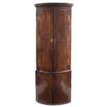 An early 18th Century walnut, crossbanded and feather strung bow-fronted standing corner cupboard:,