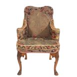 A carved walnut armchair in the early 18th Century taste:, upholstered in gros-point tapestry,