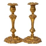 A pair of 19th century gilded copper candlesticks: with acanthus decorated nozzles on a knopped and
