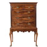 The upper part of a George III mahogany tallboy:, on a later stand, with a moulded dentil cornice,
