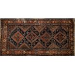 A Melayer rug:, the indigo field with four serrated lozenge and geometric flowerhead medallions,
