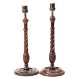 A matched pair of mahogany barley twist candlesticks: with cast brass acanthus decorated nozzles,