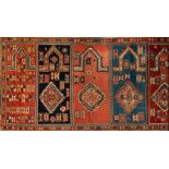 A Shirvan Saph or family prayer rug:, having seven geometric mihrabs in colours of brick red,