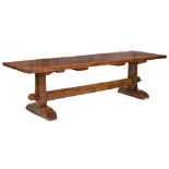 An oak refectory table: with a three plank cleated top, on dual trestle end supports,