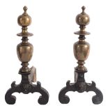 A pair of late 16th Century bronze and wrought iron andirons: the scroll legs centred by lion masks,