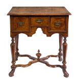 A William & Mary walnut and feather banded lowboy: the rectangular quarter veneered top with a