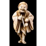A Japanese carved ivory netsuke of a travelling priest or poet: the smiling man wearing a flowing