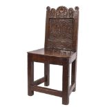 A 17th Century carved oak child's chair: the back with shaped arcaded top rail with flowerhead and