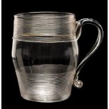 An English glass tankard: of barrel shaped form with strap handle decorated below the rim and above