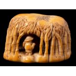 An unusual Japanese carved ivory netsuke: of a bamboo farmer inside a canopy of bamboo branches,
