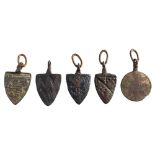 Five late Medieval horse harness pendants: includes four shield-shaped examples and a circular