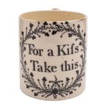 An English creamware small mug: printed in black 'For a Kifs/ Take this' within a foliate cartouche,