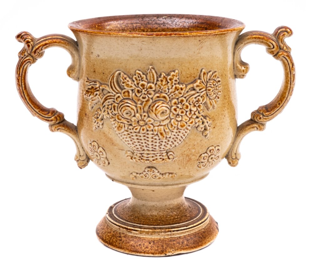 A Brampton salt glazed stoneware loving cup: of goblet-shaped form with scroll handles and foliate