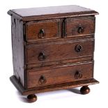 A 17th Century miniature oak chest of drawers: the rectangular top with a moulded edge containing