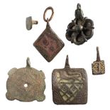 Five late Medieval horse harness pendants: includes a red enamel A or H pendant,