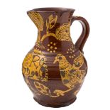 A late 18th Century slipware baluster jug: decorated in cream slip on the brown ground with birds,