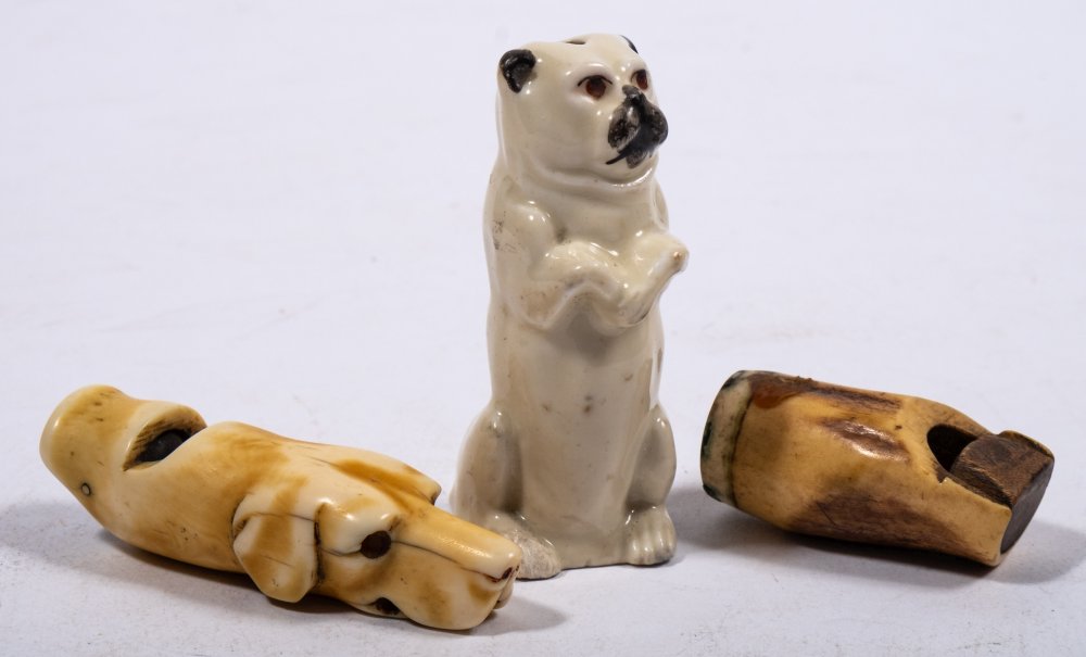 An early 20th century Continental porcelain pug dog whistle: with single reed to interior,