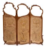 A French carved walnut and embroidered panel three fold graduated screen:,