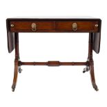 A Regency mahogany sofa table:, the hinged top with rounded corners and a reeded edge,