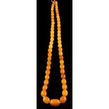 A graduated amber bead single-string necklace: with 55 oblong beads graduating from 9mm long to