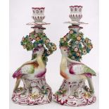 A pair of Continental exotic bird candlesticks in the Chelsea style: on rococo mound bases with