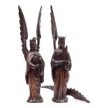 A pair of 19th Century Continental carved oak figures of angels: each with outstretched wings,